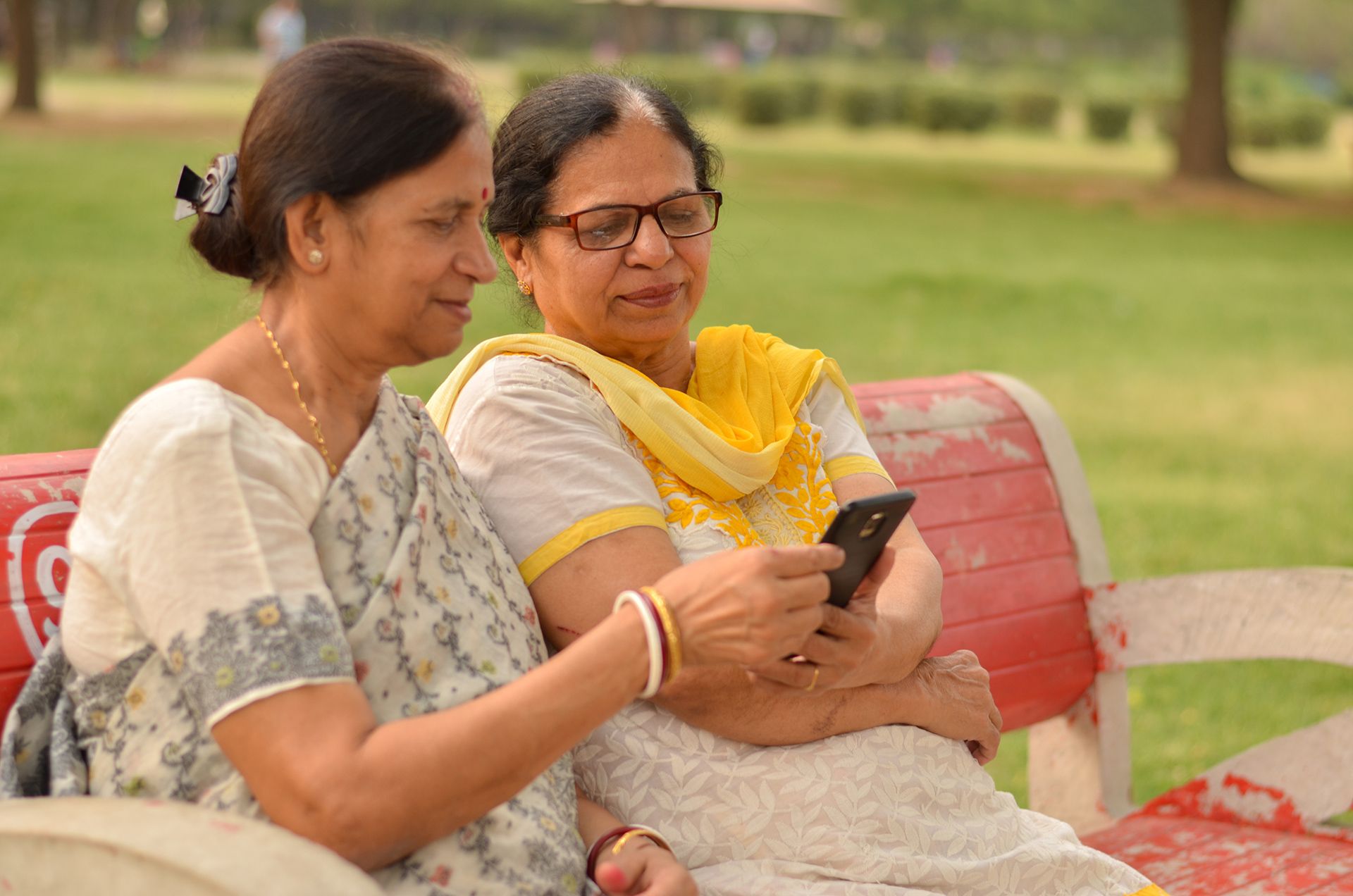 Indian women sharing a phone